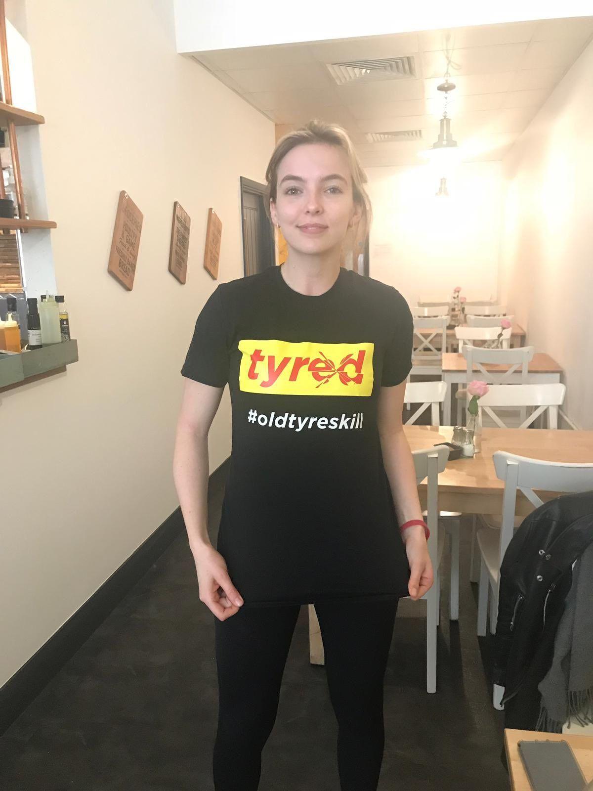 Jodie Comer wearing a shirt showing the Tyred logo